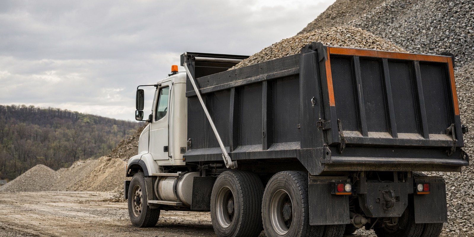 Dump truck and crushed stone stockpiles at a Laney materials yard